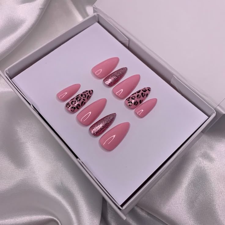 Pink almond press-ons with leopard print and glitter accent nails in a white box